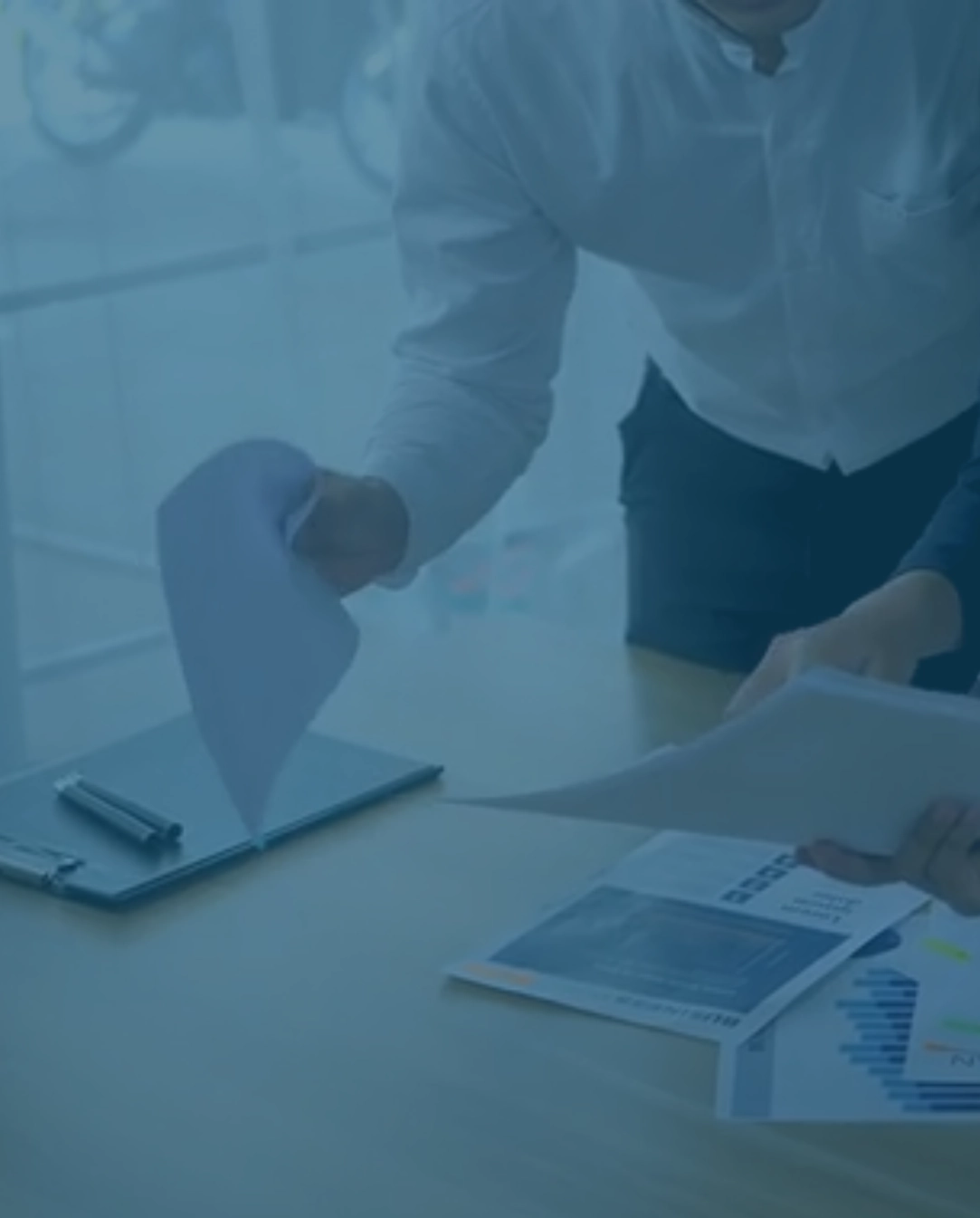Team analysiert bunte Charts und Dokumente am Tisch – gemeinsam IT Prozesse optimieren und datenbasiert Entscheidungen treffen.